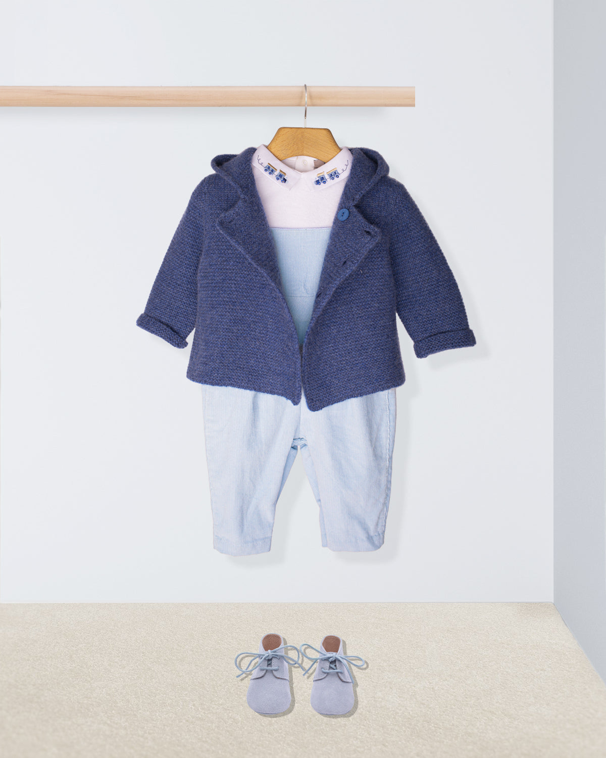 Baby outfit with blue jacket, pants, and shoes on a white background