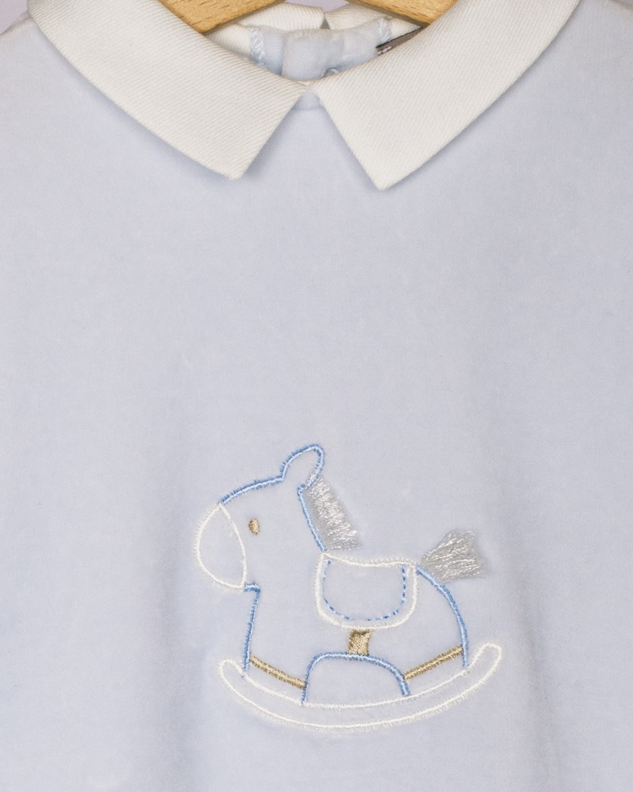 Light blue shirt with embroidered rocking horse design on a white background