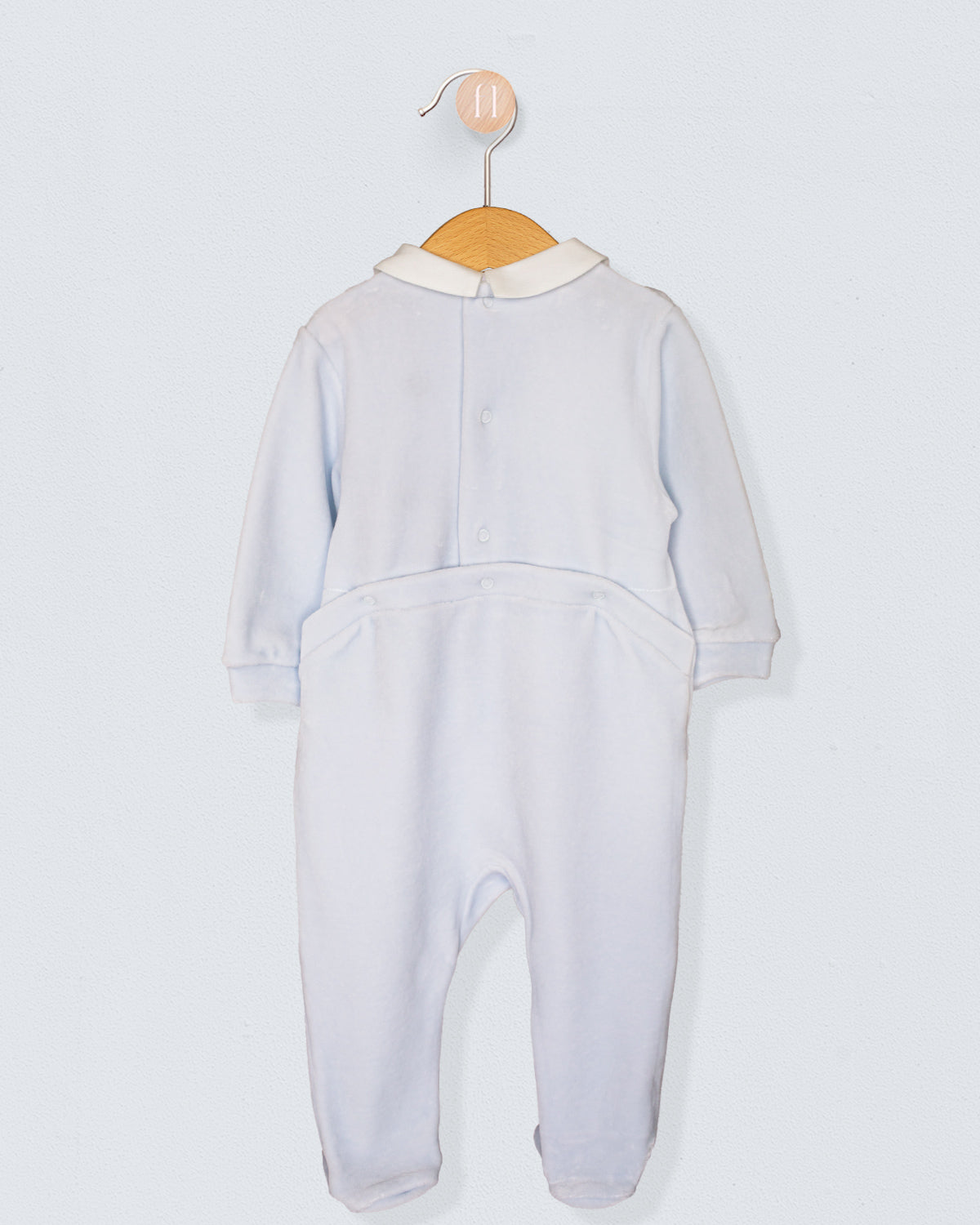 Back view of light blue Italian velour footie with snap closures and ivory Peter Pan collar, shown on a wooden hanger.