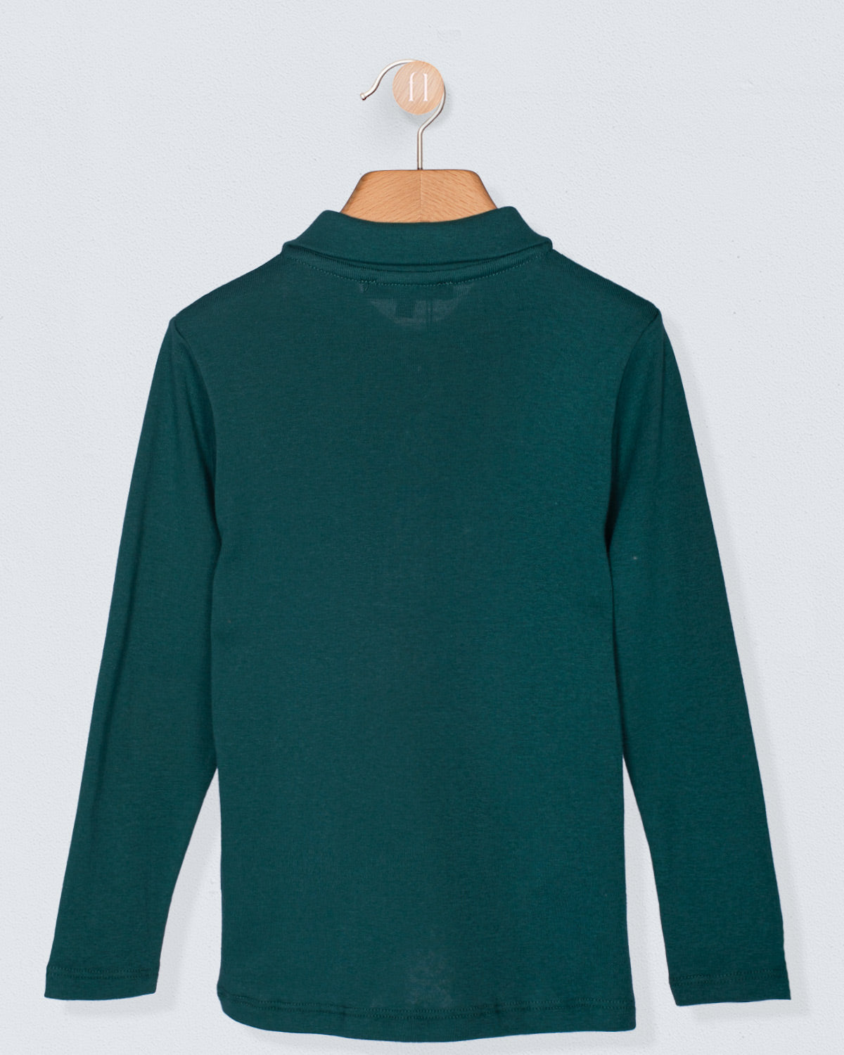 Back view of the long-sleeve hunter green polo shirt displayed on a wooden hanger, highlighting the clean lines and smooth brushed cotton fabric. Back closure features subtle snap detailing.