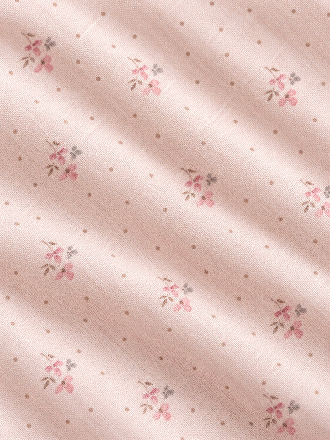 Close up of a light pink blush delicate fabric with pink flower motif design