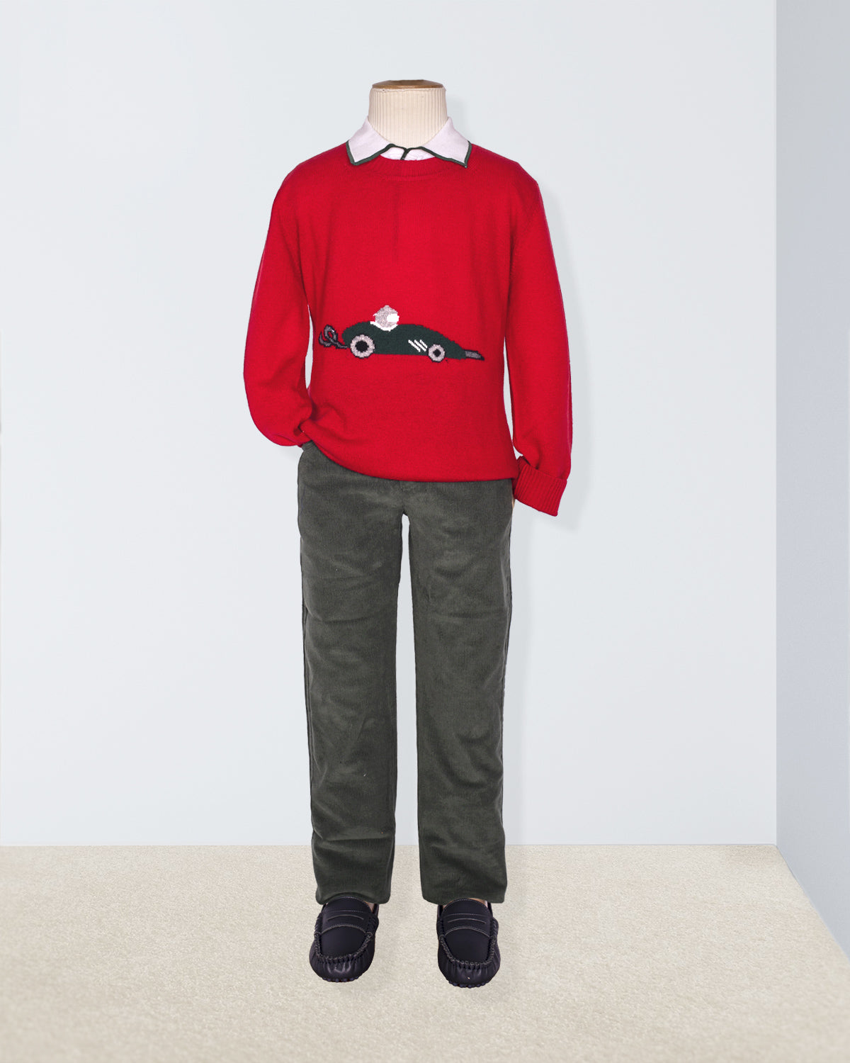 Red sweater with a car design on a mannequin against a white background