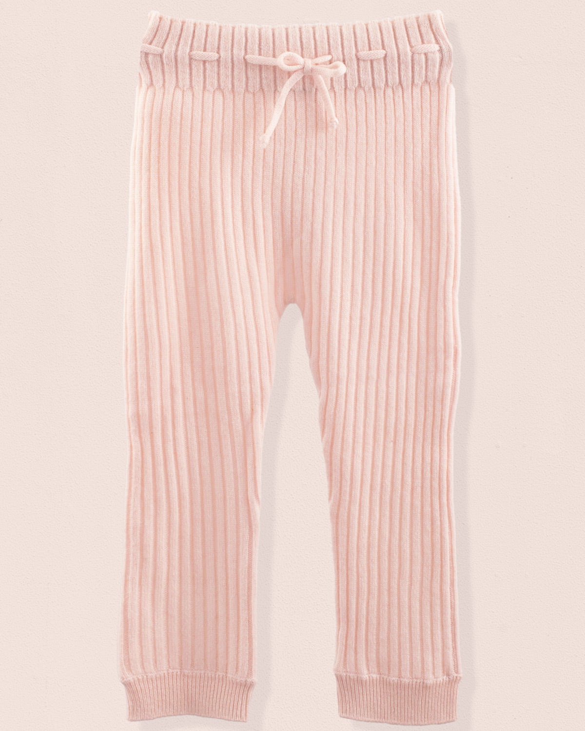 Pink ribbed jogger pants on a light pink background