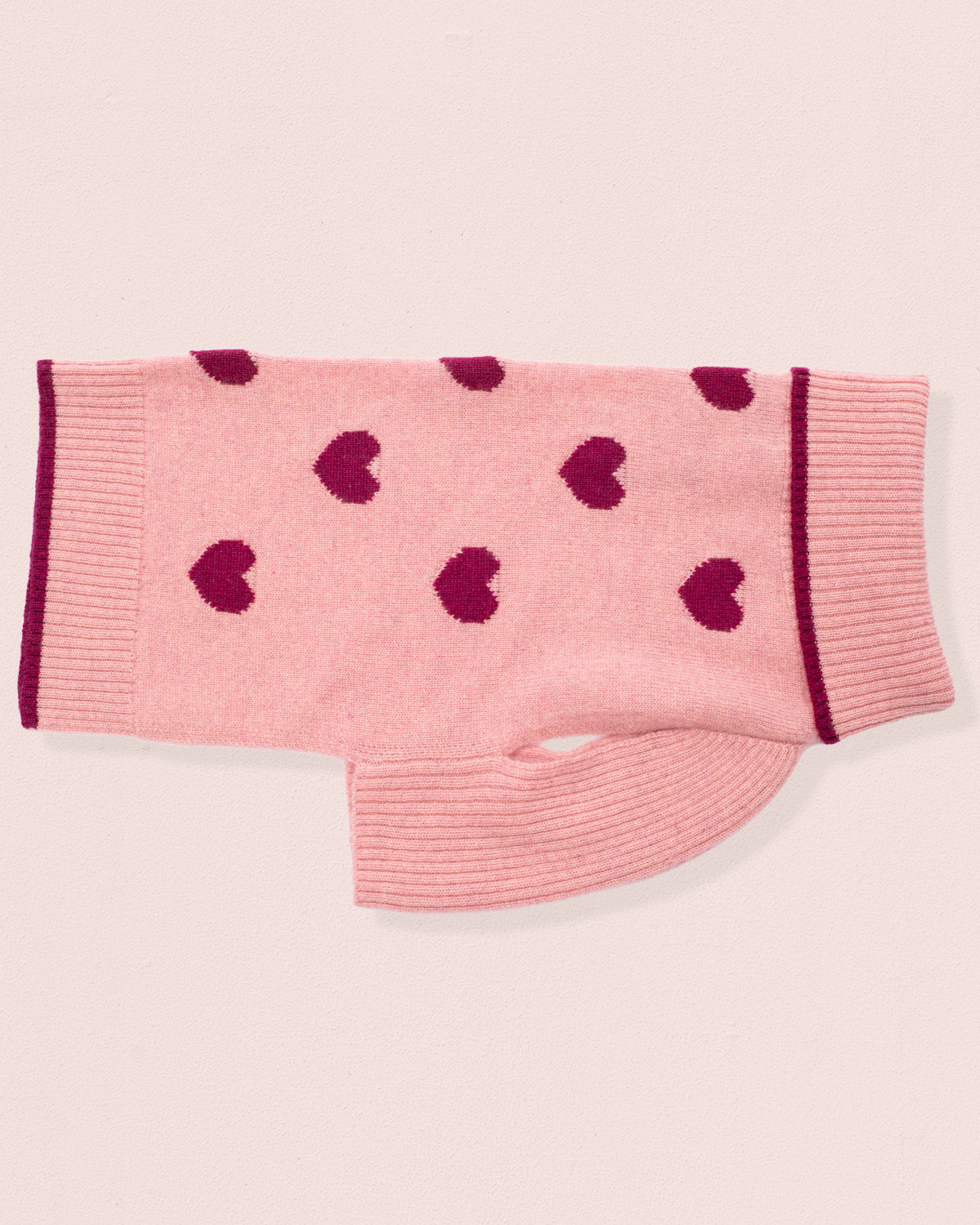 Cashmere sweater for dogs, with dark pink heart patterns on a light pink background