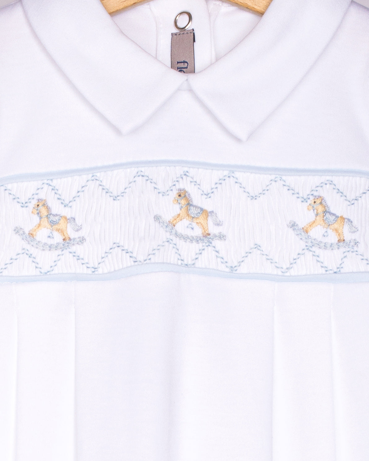 White shirt with embroidered horse design on a hanger