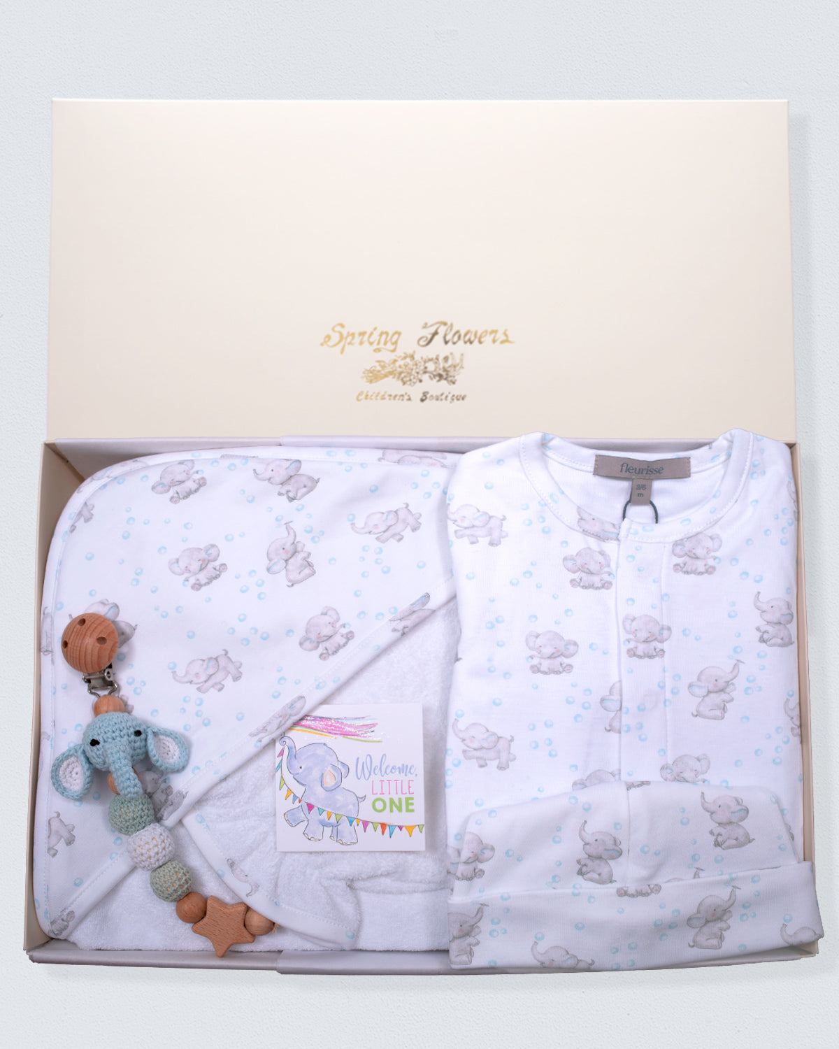 Baby gift set with white blanket, teether, and elephant toy in a box with 'Spring Flowers' branding.