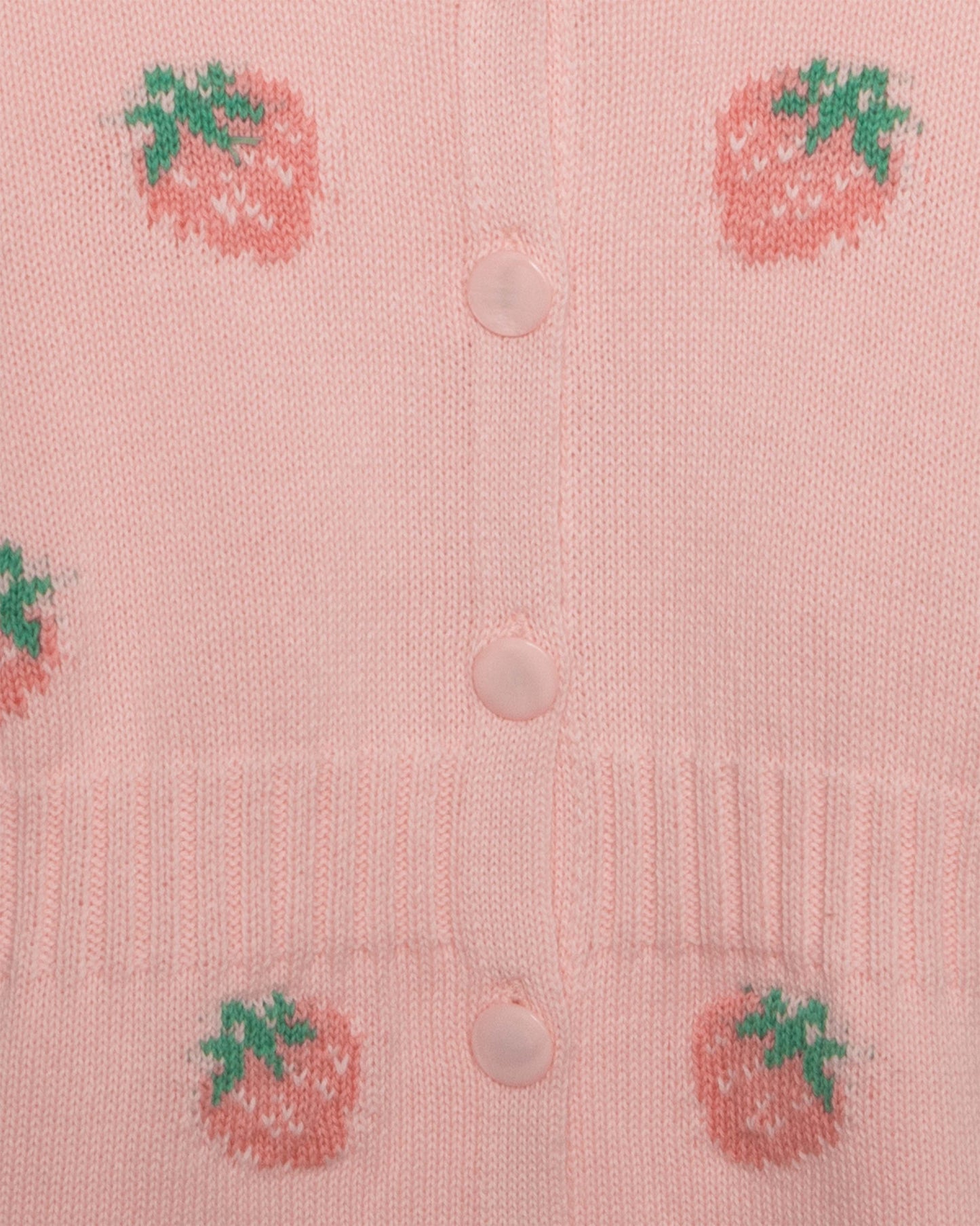 Pink cardigan with strawberry patterns and buttons on a light pink background