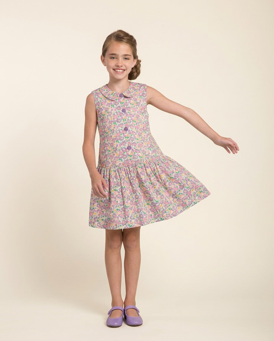 Young girl wearing a floral dress on a beige background