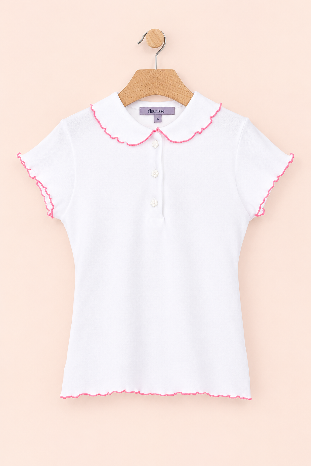 White blouse with pink trim on a hanger against a beige background