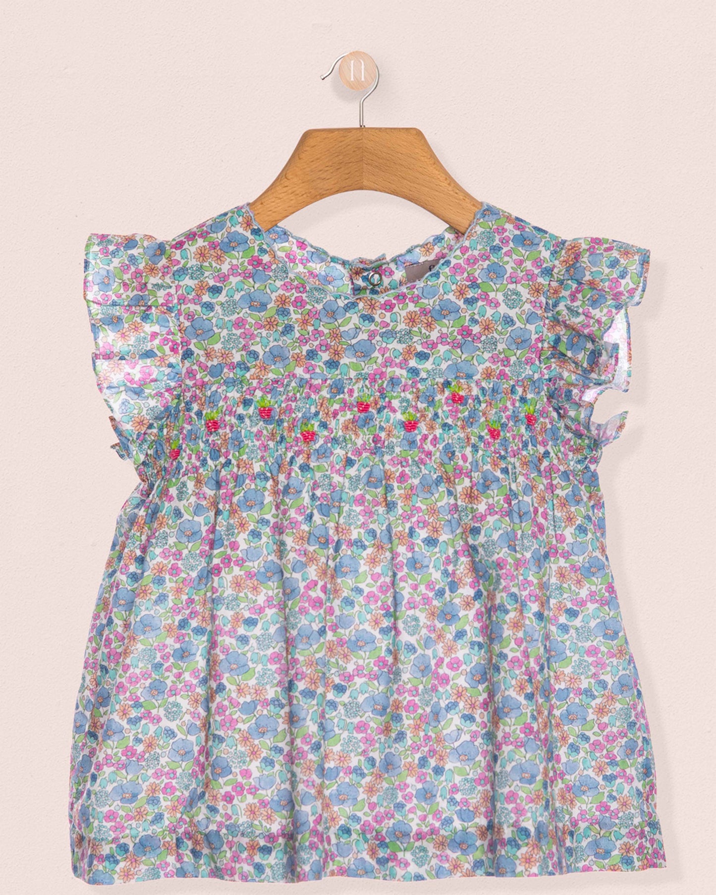 Floral dress on a hanger against a light background