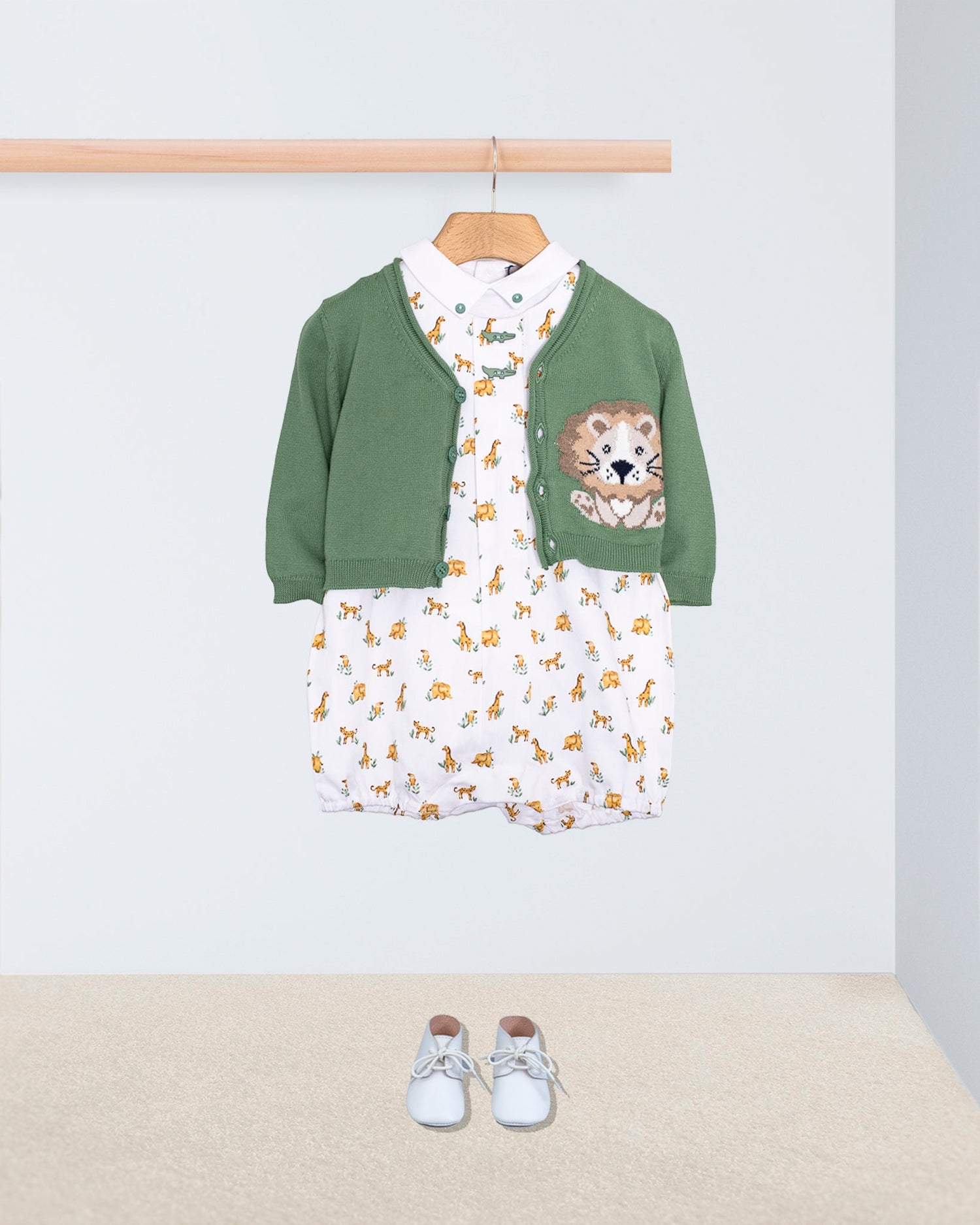 William Onesie romper in safari print with a t-shirt and a cardigan on a hanger