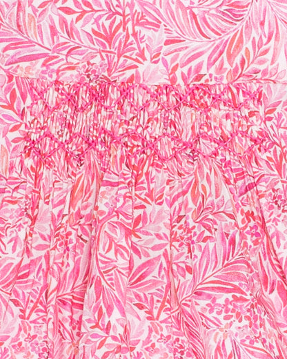 Close-up of the Amelie Liberty Wallace Garden Tunic showing intricate hand-smocking on a vibrant pink Liberty print with leafy floral patterns in light pink and white.