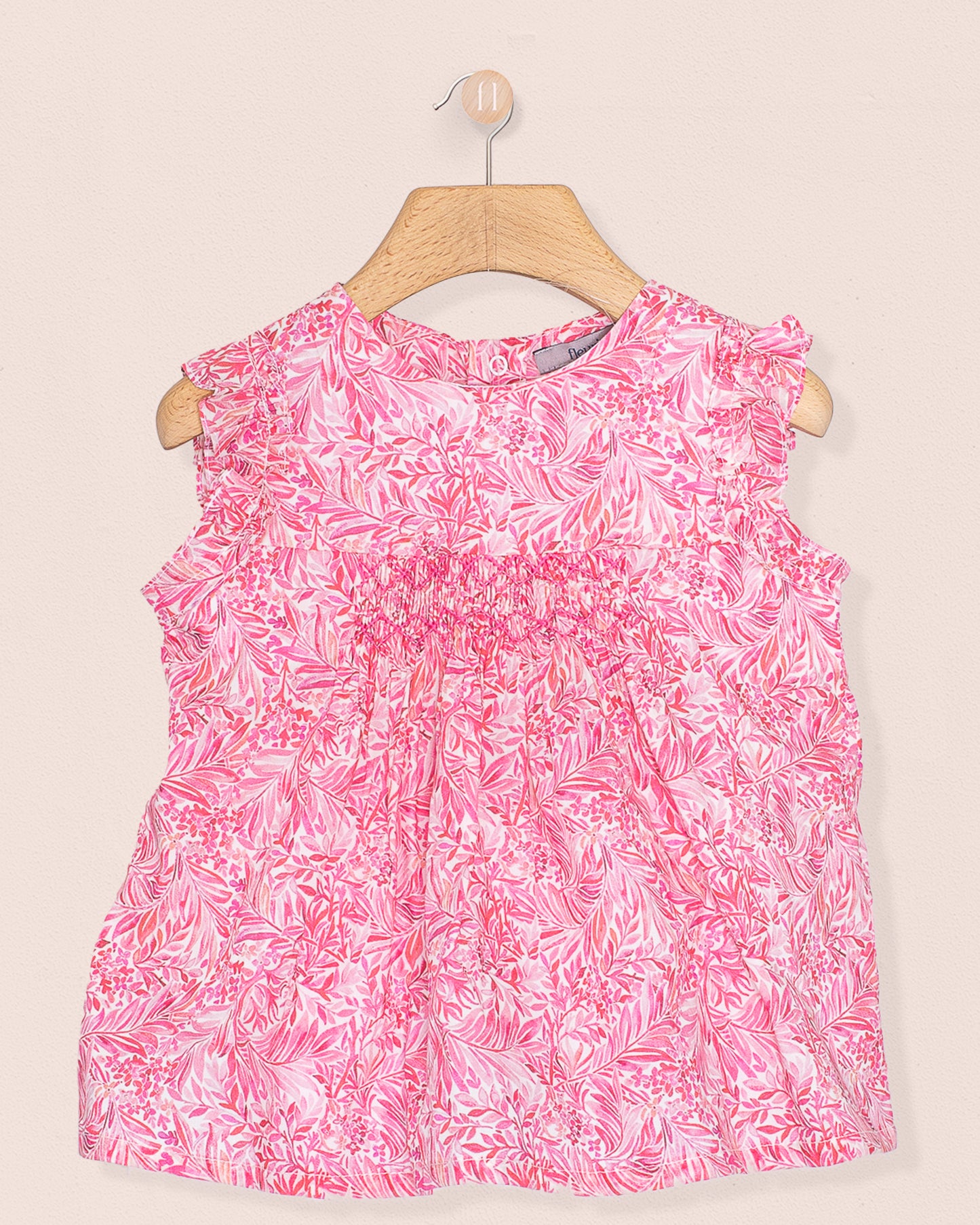 Front view of the Amelie Liberty Wallace Garden Tunic, a sleeveless A-line top with hand-smocked detailing and ruffled sleeves in a vivid pink and white botanical Liberty of London print.