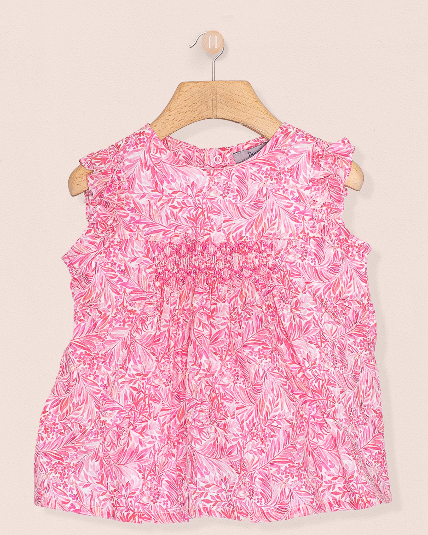 Front view of the Amelie Liberty Wallace Garden Tunic, a sleeveless A-line top with hand-smocked detailing and ruffled sleeves in a vivid pink and white botanical Liberty of London print.