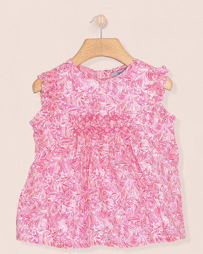 Front view of the Amelie Liberty Wallace Garden Tunic, a sleeveless A-line top with hand-smocked detailing and ruffled sleeves in a vivid pink and white botanical Liberty of London print.