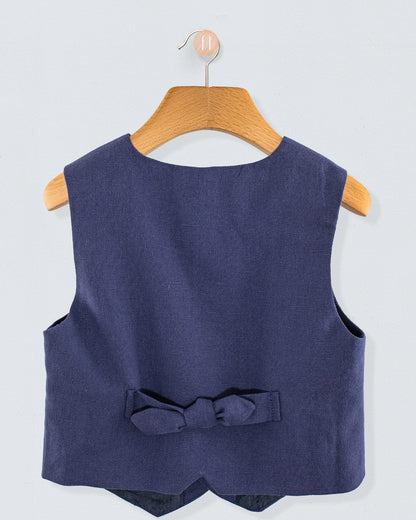 Back view of navy linen vest featuring a decorative bow at the waist, shown on a hanger