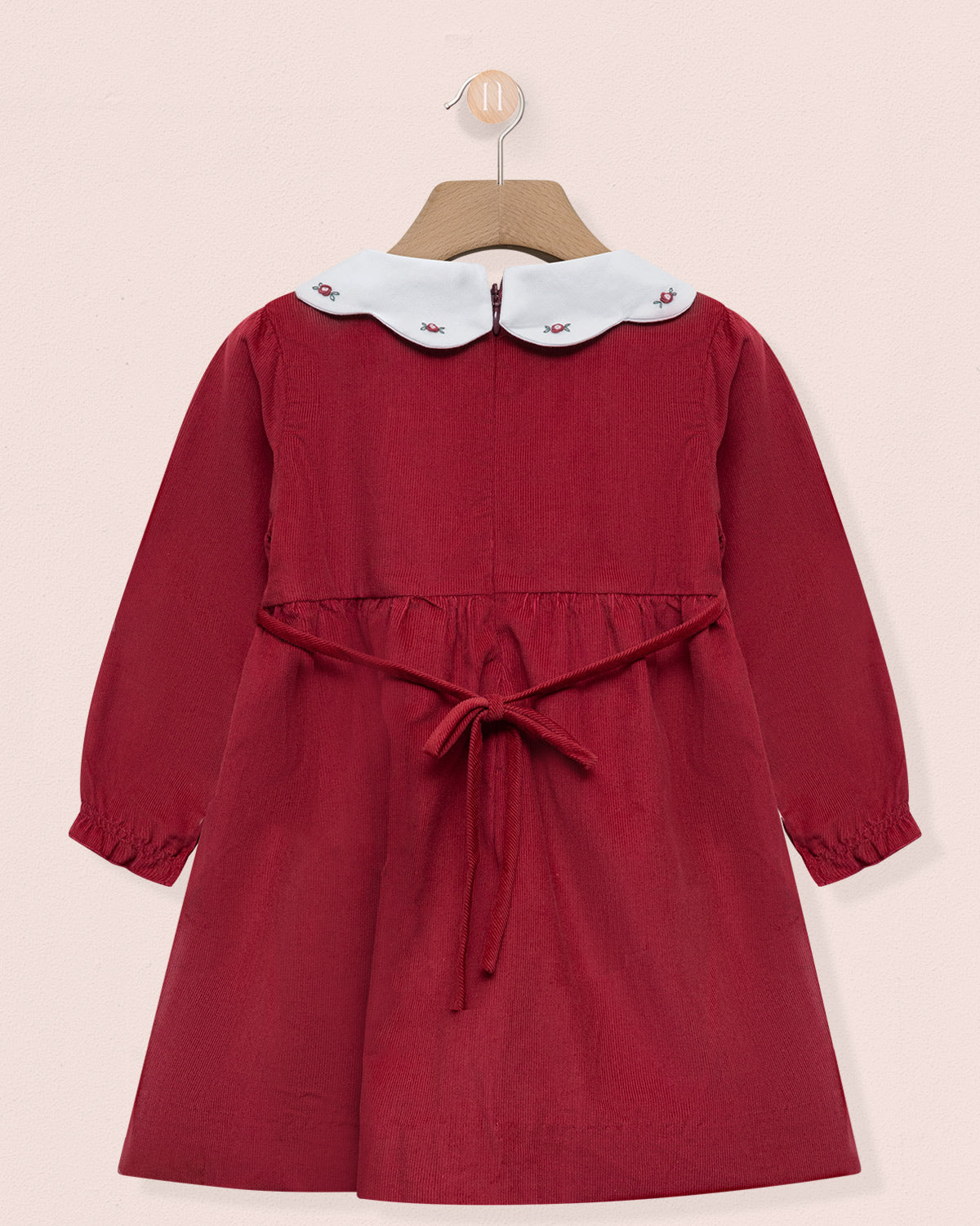 Red dress with a white collar on a pink background