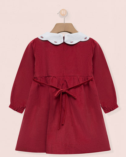 Red dress with a white collar on a pink background