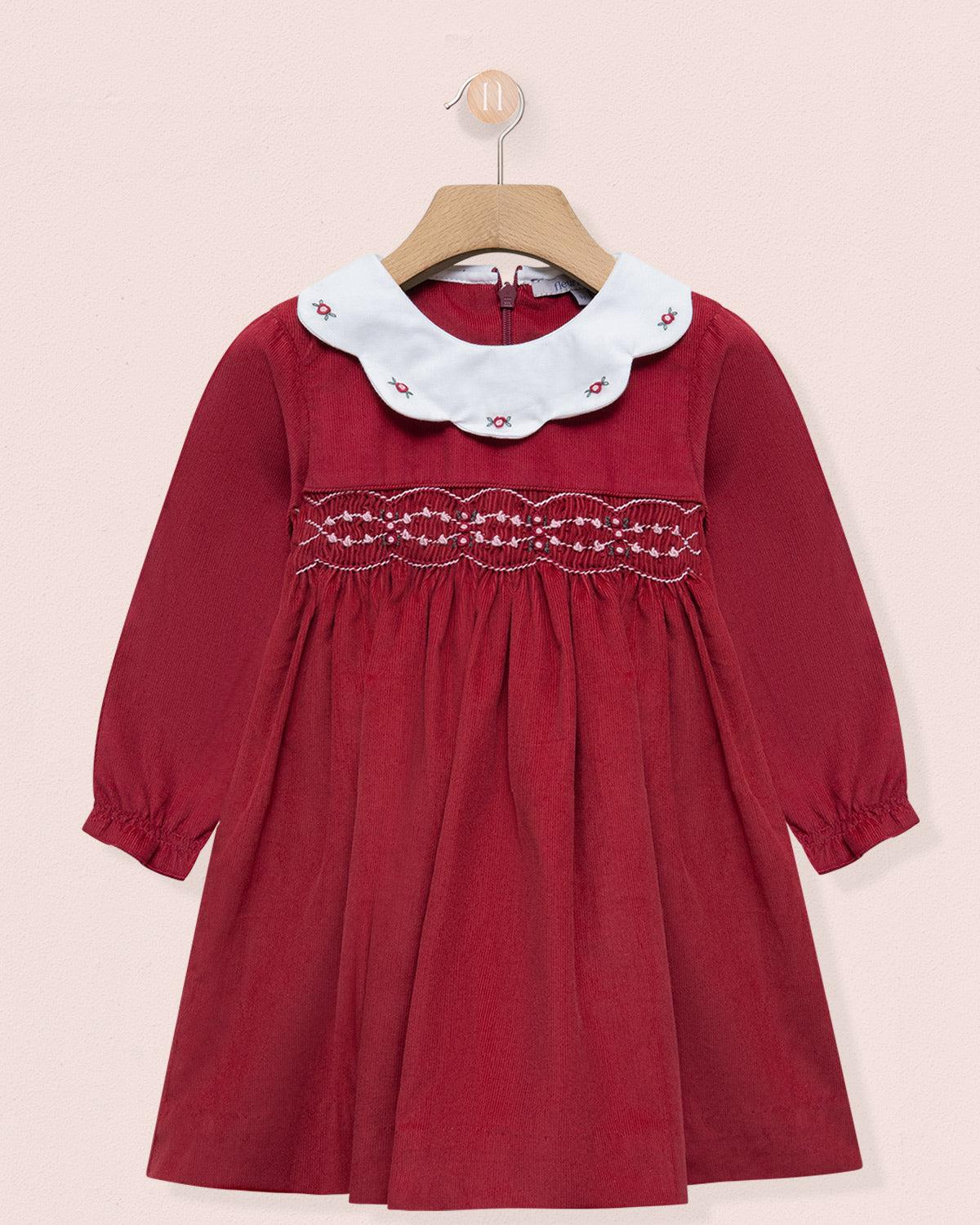 Red dress with white lace collar on a beige background