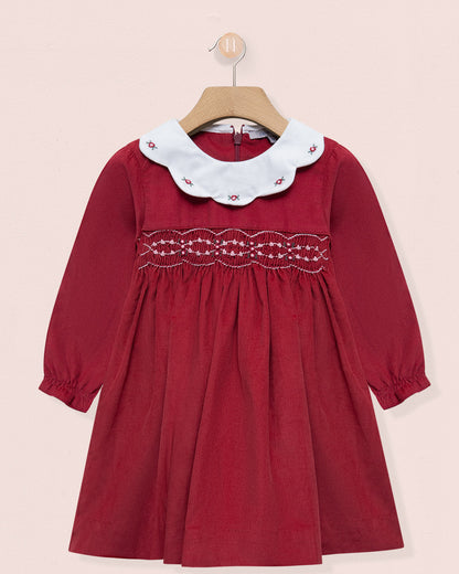 Red dress with white lace collar on a beige background