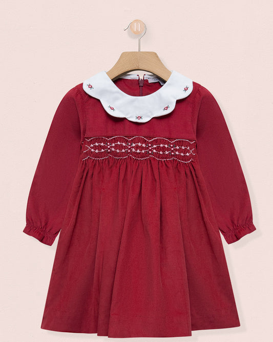 Red dress with white lace collar on a beige background