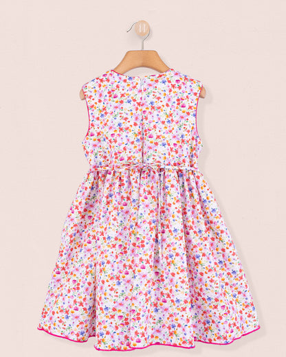 Back view of the Amandine Veneto Hot Pink Garden Smock dress featuring a concealed zip closure and gathered skirt in a lively floral print on white cotton.