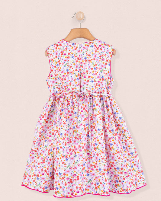 Back view of the Amandine Veneto Hot Pink Garden Smock dress featuring a concealed zip closure and gathered skirt in a lively floral print on white cotton.