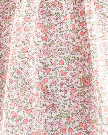 Close-up of the Baby Amelie Garden Pink Set fabric showing pink and coral floral print on white cotton with green leaf detailing