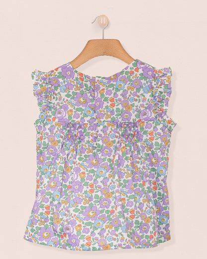 Back view of the Amelie Liberty Betsy Lavender Tunic featuring ruffled sleeves and a hidden snap opening, in a colorful Liberty floral pattern on lightweight cotton.