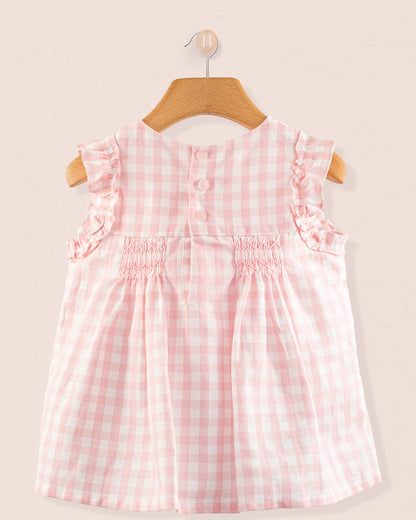 Back view of the Amelie Pink Gingham Linen Tunic showing a delicate smocking detail and a concealed snap closure in a pale pink and white gingham linen blend.