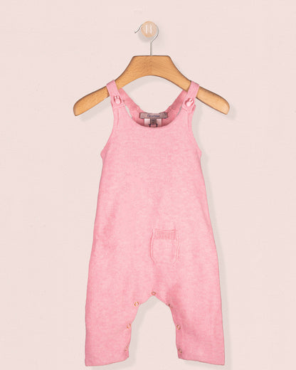 Aspen Candy Mélange pink cotton knit overall hanging on a wooden hanger with front pocket detail