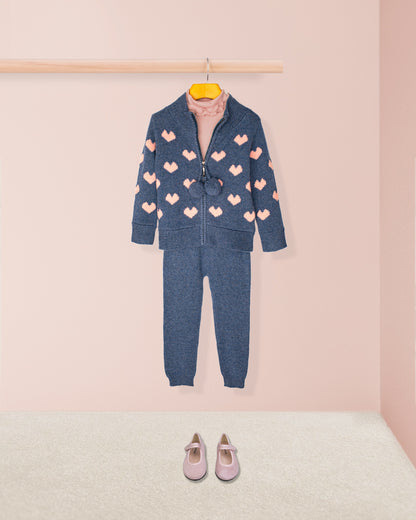 Children's blue outfit with pink heart patterns on a pink background