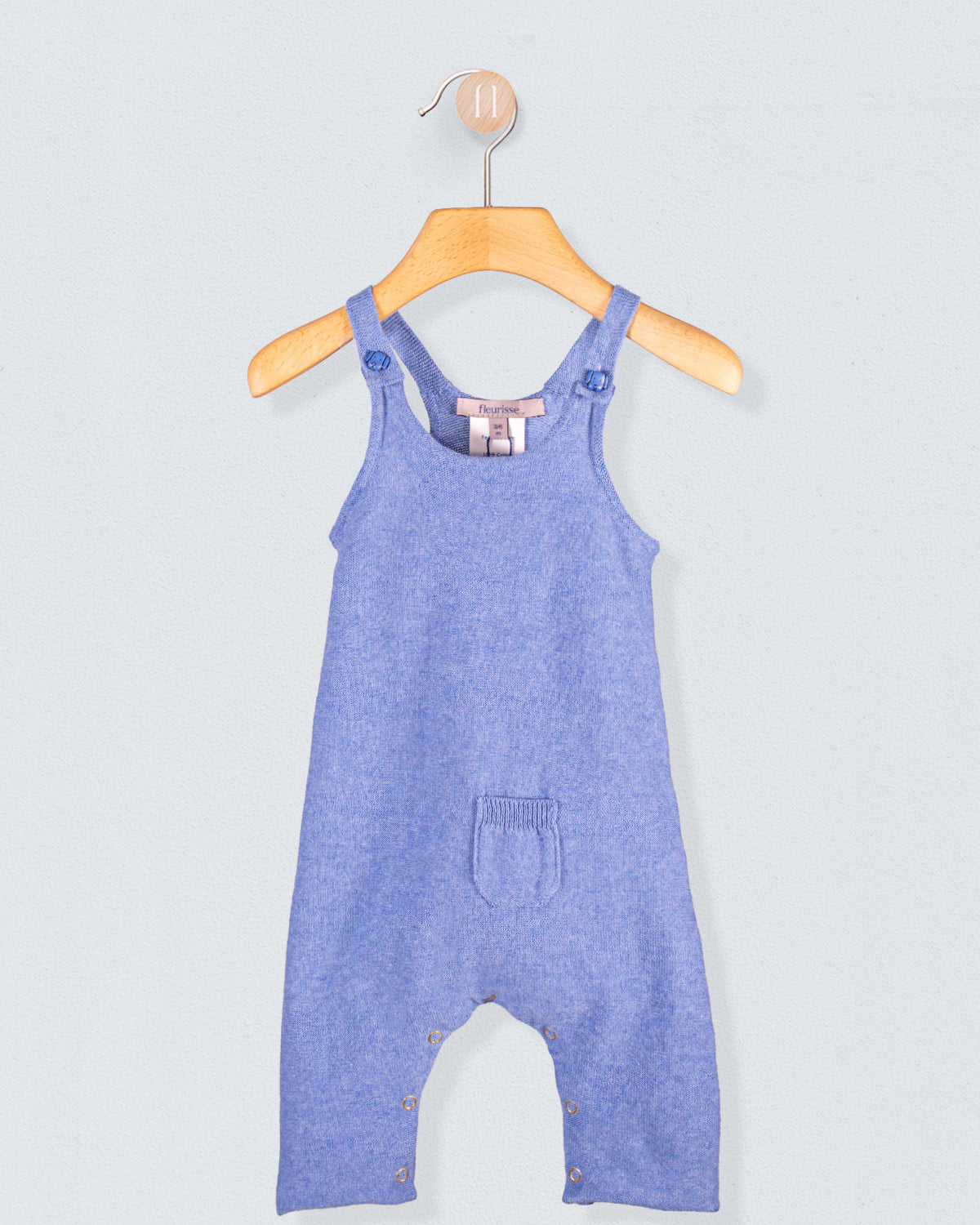  Aspen Jean Mélange cotton knit overall hanging on a wooden hanger with front pocket detail