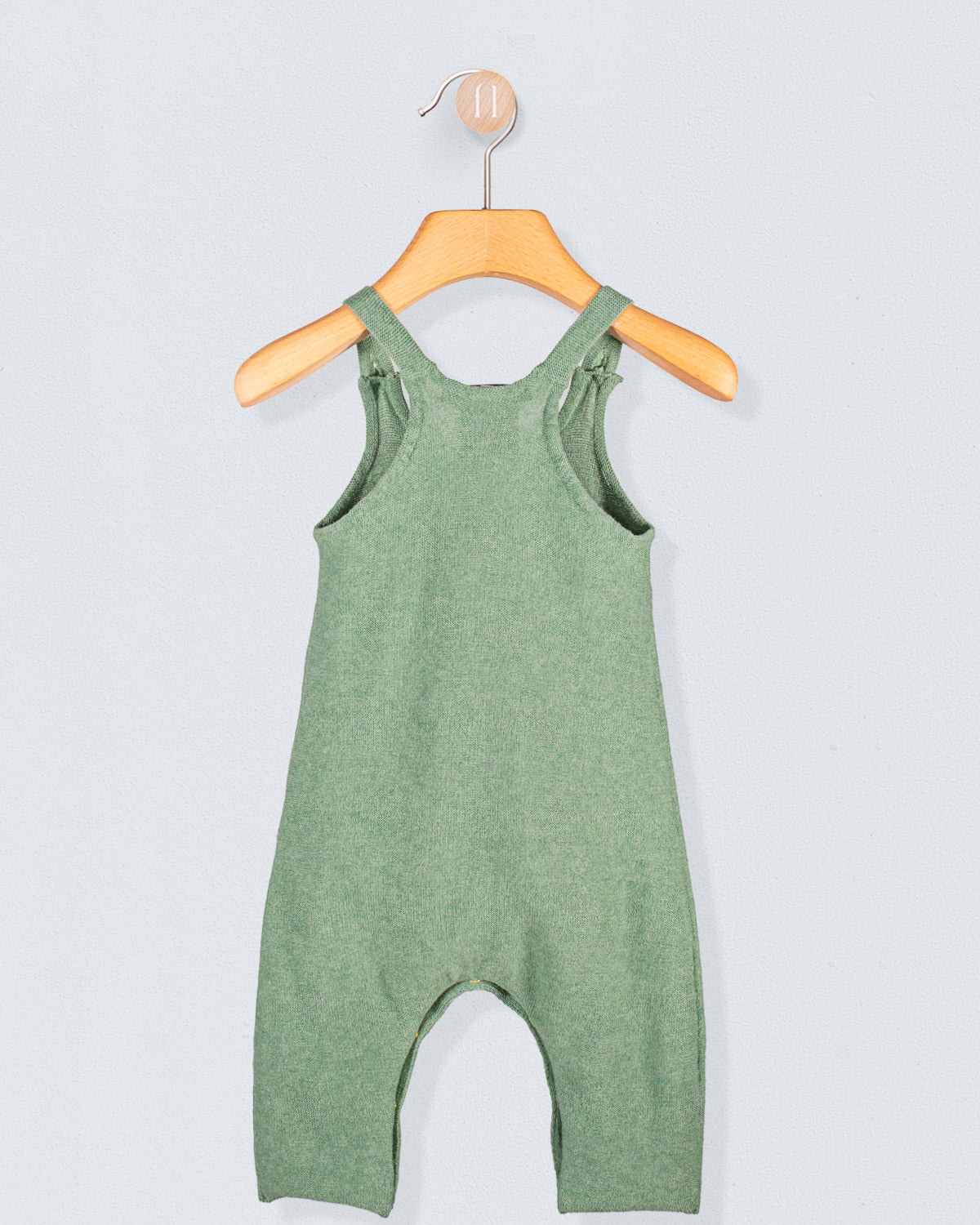 Back view of Aspen Sage Melange Cotton Knit Overall hanging on a wooden hanger