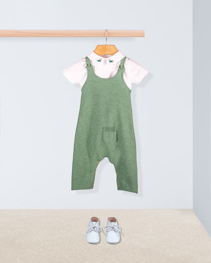 Aspen Sage Melange Cotton Knit Overall styled with a white embroidered collar onesie and white shoes laid out on a beige carpet