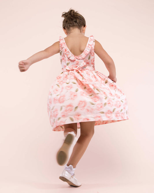 Girl turned to the back, twirling while wearing the Ella Bianca Roses Dress showing the back gof the dress