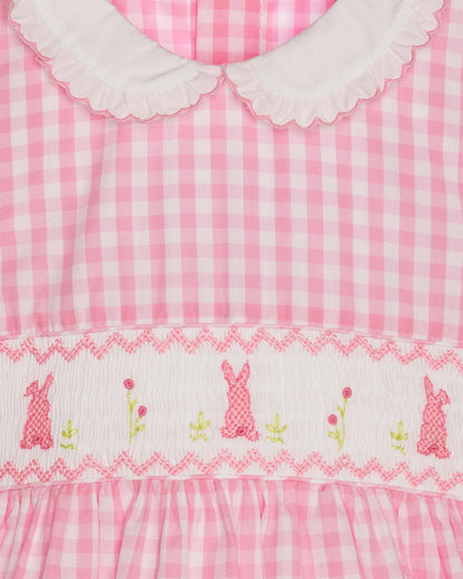 Pink gingham dress with embroidered bunnies and flowers on a white background