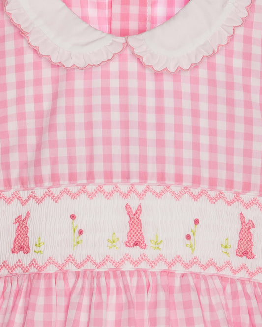 Pink gingham dress with embroidered bunnies and flowers on a white background