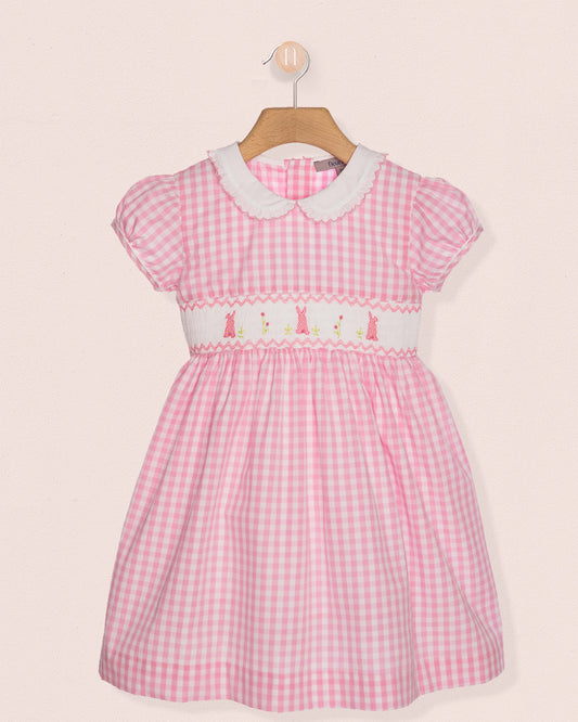 Pink checkered dress with white collar on a beige background