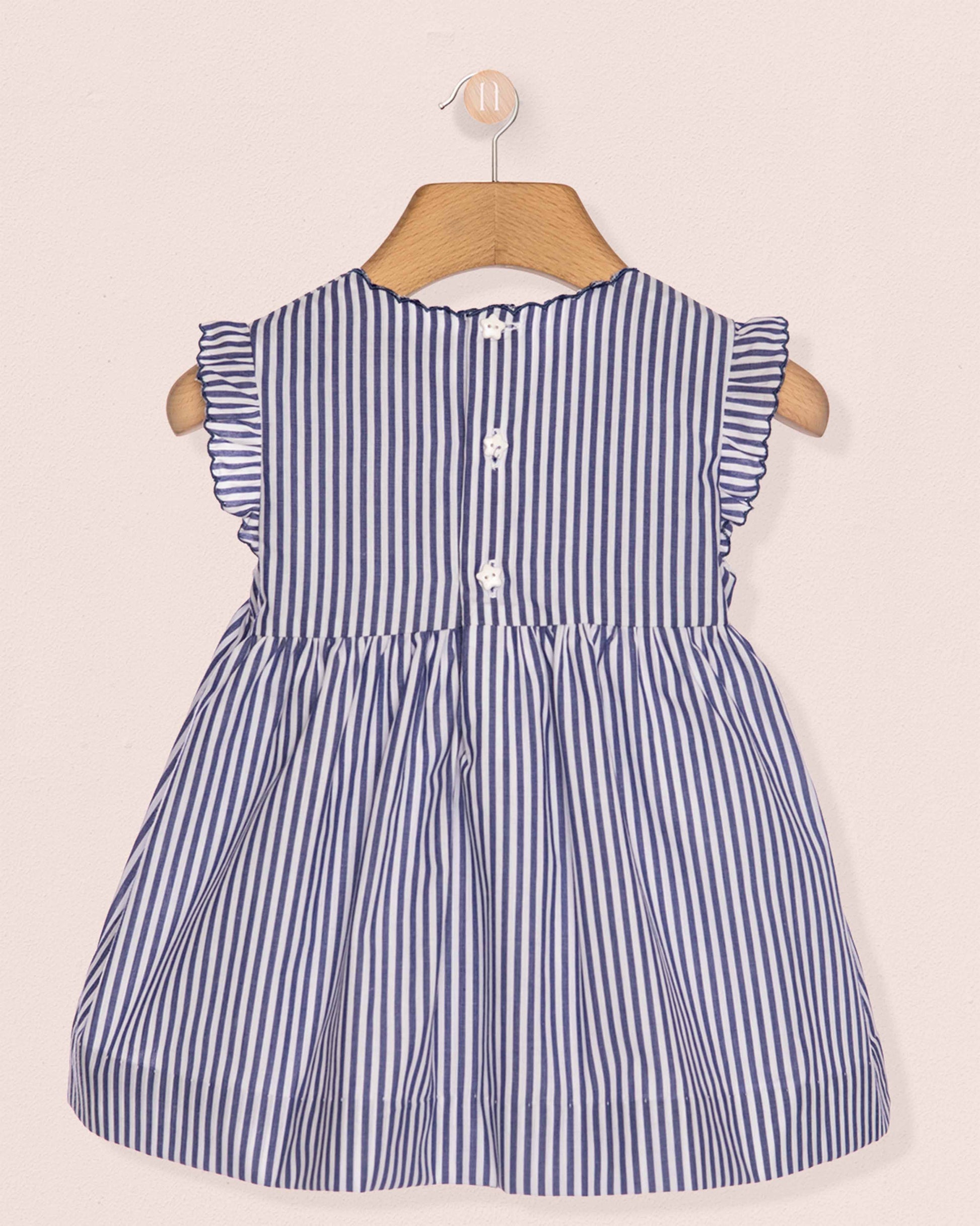 Blue and white striped dress on a hanger against a beige background