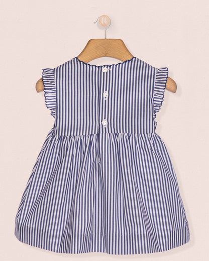 Blue and white striped dress on a hanger against a beige background