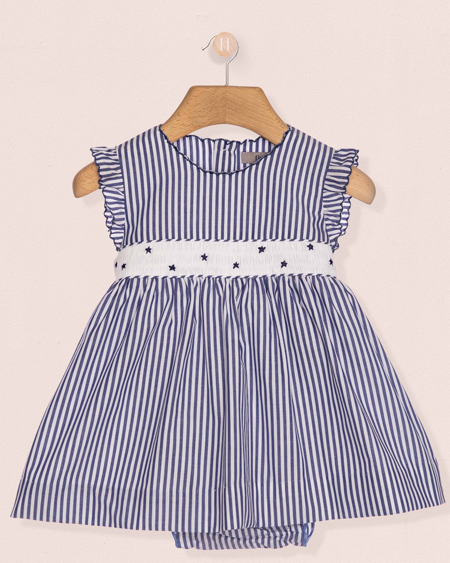 Blue and white striped dress with star details on a beige background