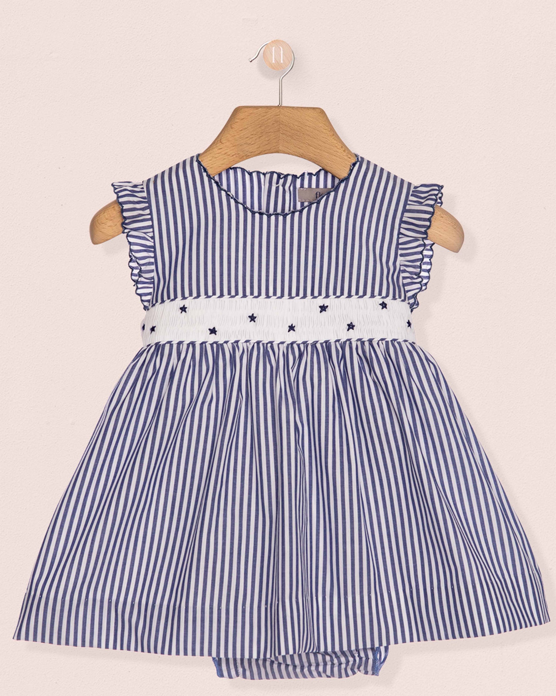 Blue and white striped dress with star details on a beige background