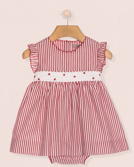 Red and white striped baby dress with star details on a pink background