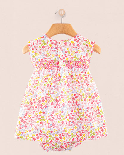 Back view of Baby Amelie floral dress showing gathered waist detail and fabric flow on hanger
