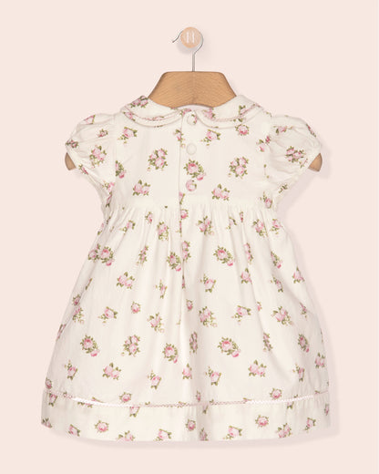 Floral dress on a mannequin against a light pink background