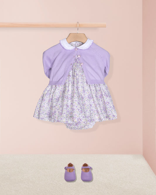 Lavender dress with floral pattern and matching shoes on a pink background