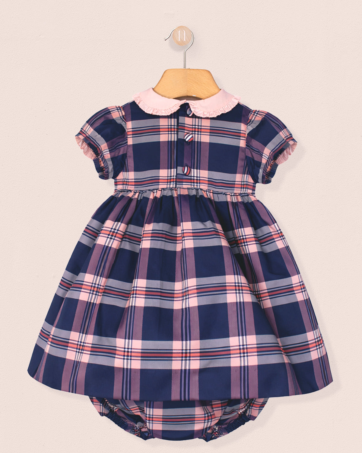 Navy and pink plaid dress with a matching bloomers set on a beige background