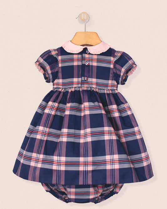 Navy and pink plaid dress with a matching bloomers set on a beige background