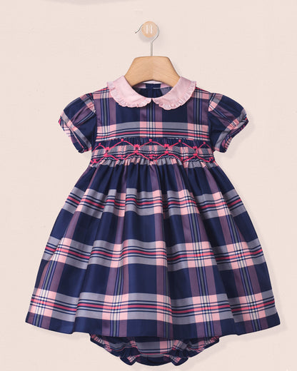 Navy and pink plaid dress with a pink collar on a beige background